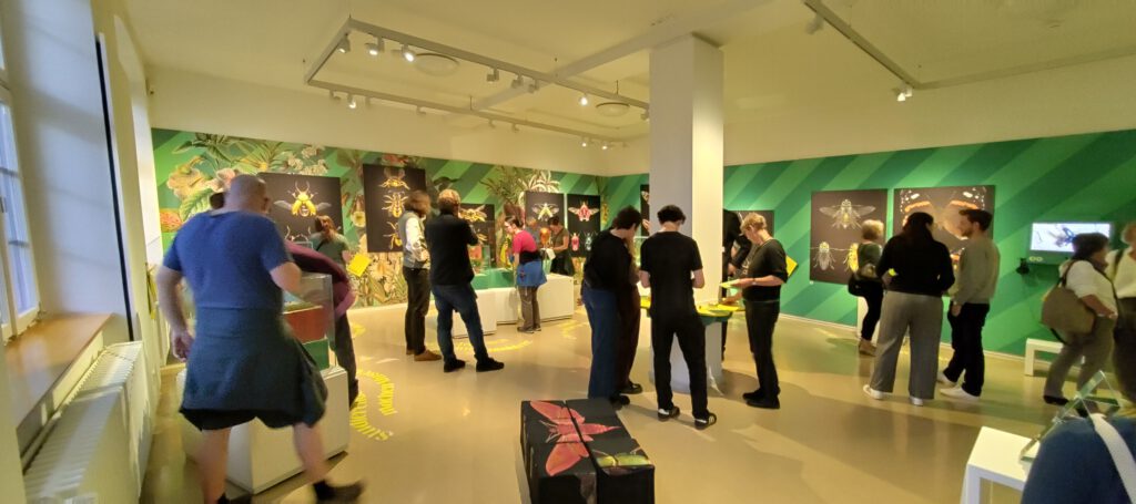 Menschen schauen sich eine Ausstellung zum Thema Insekten an. warme Beleuchtung, satte Farben